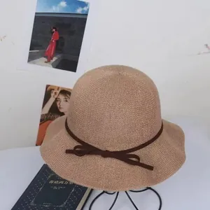 Women's sun protection straw bucket hat with bow accent and elegant wavy brim