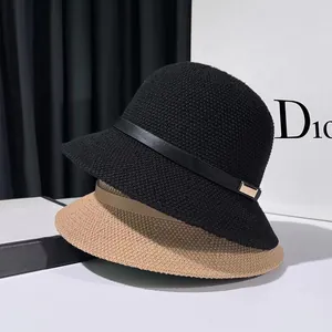 Detail view of knitted bucket hats in black and khaki with elegant leather decorative bands