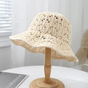Detail of hollow-out crochet bucket hat with geometric patterns in cream color