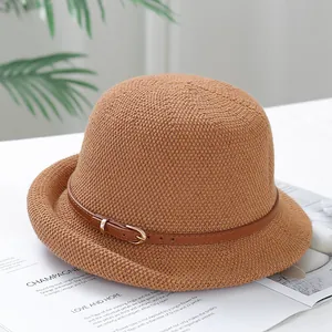 Brown woven bucket hat with leather belt strap and metal buckle on white background