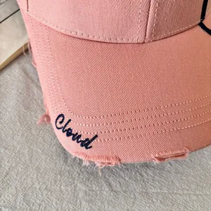 Primer plano de gorra de algodón rosa con bordado Cloud y detalles desgastados