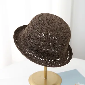 Gros plan détaillé sur le tissage tricoté ajouré marron foncé du chapeau cloche