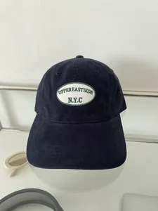 Casquette de baseball en coton bleu marine avec broderie UPPEREASTSIDE sur fond blanc
