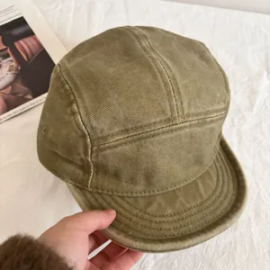 Detail of olive green five-panel cap featuring reinforced brim and heavy cotton twill fabric