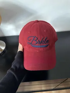 Detalle de gorra de béisbol de algodón granate con bordado Brkln en azul