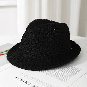Close-up of breathable hollow-out crochet texture on a black summer straw sun hat