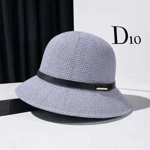 Detailed close-up of lavender woven bucket hat with black leather band and gold buckle