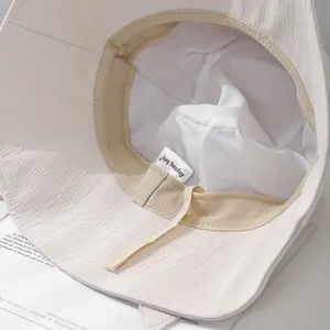 Détail de la doublure en maille respirante et du cordon réglable du chapeau de soleil beige