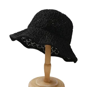 Classic black crochet hollow bucket hat displayed on a wooden stand for summer sun protection