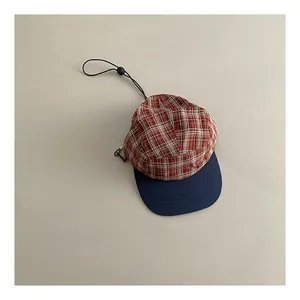 Detail of vintage plaid baseball cap showing fabric texture and adjustable drawcord