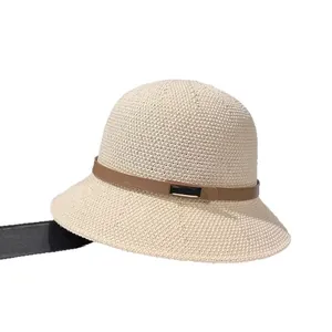 Minimalist beige woven straw bucket hat with a stylish brown leather band and metal buckle