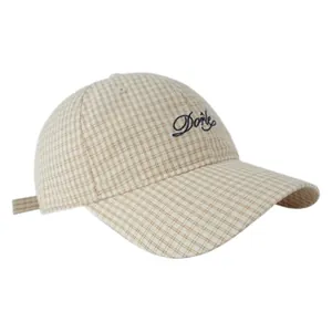 Dettaglio del cappellino vintage a quadri con elegante ricamo Dorie su tessuto kaki