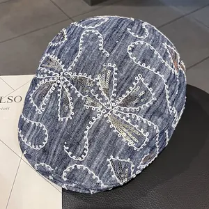 Detaillierte Stickerei mit Gold- und Silberpailletten auf blauer Denim-Baskenmütze