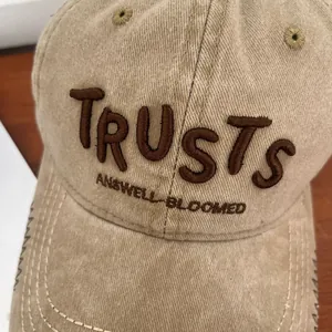 Close-up of vintage khaki cotton baseball cap with 3D embroidery and frayed brim details