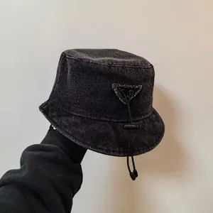 Close-up of black washed denim bucket hat with side triangle patch and drawstring detail