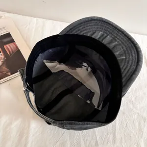 Detail of grey washed denim baseball cap featuring internal sweatband and adjustable buckle