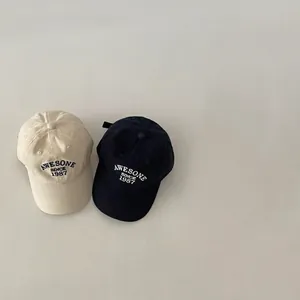 Set of two vintage American baseball caps in cream and navy with retro embroidery