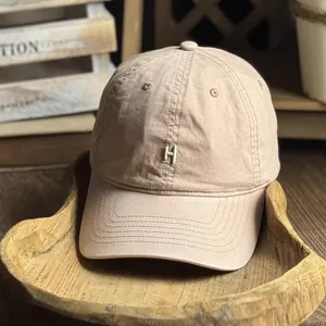 Detail of vintage washed khaki cotton baseball cap featuring embroidered H logo