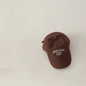 Detail view of coffee brown baseball cap with white Awesome Since 1987 embroidery