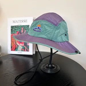 Close-up of mountain peak embroidery and outdoor camp text on the mesh hiking hat