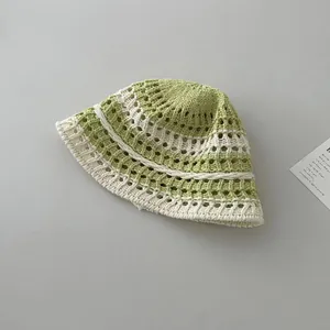 Close-up of handmade crochet bucket hat with hollow knit floral pattern in green and beige