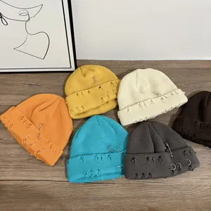 Berretti in maglia colorata con anelli metallici e dettagli strappati dall'effetto vintage