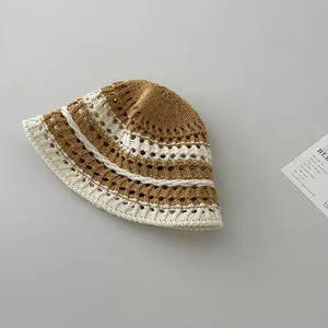 Detailed macro view of hollow-out floral knit patterns on a striped crochet bucket hat