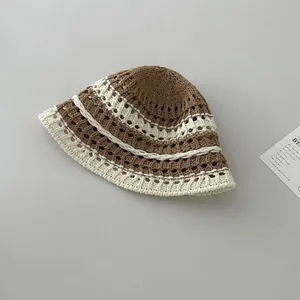 Close-up of handmade crochet bucket hat with hollow flower pattern and brown stripes