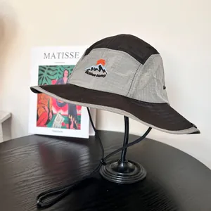 Detail of mountain embroidery on a color-blocked ripstop outdoor hiking bucket hat