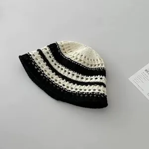 Detailed close-up showing the hollow-out crochet texture of the striped knitted bucket hat