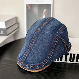 Detail der Denim-Schirmmütze mit orangefarbenen Nähten und verstellbarer Schnalle auf Holz