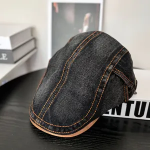 Detail der Vintage Schiebermütze aus schwarzem Denim mit orangen Nähten und Lederkante