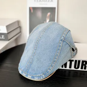 Detail der gewaschenen Jeans-Schirmmütze mit gelben Nähten und Metallschnalle