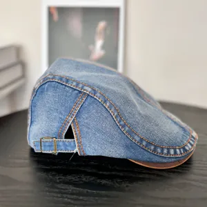 Detail der Vintage-Schiebermütze aus gewaschenem Denim mit orangen Ziernähten