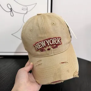 Close-up of distressed khaki denim baseball cap with New York 1989 embroidery
