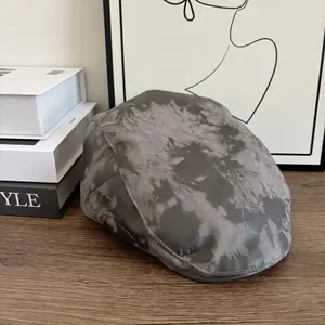 Dettaglio del basco tie-dye grigio con motivo marmorizzato su un tavolo in legno retrò