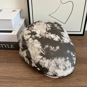 Berretto artistico con motivo tie-dye bianco e nero su superficie di legno minimalista