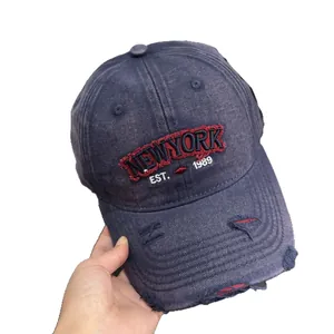 Distressed vintage washed denim baseball cap with New York embroidery and ripped details