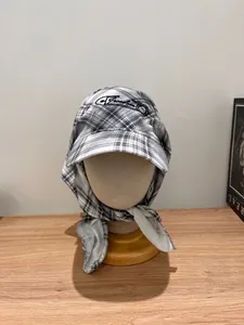 Close-up of black and white plaid headscarf hat with Freedom embroidery and brim