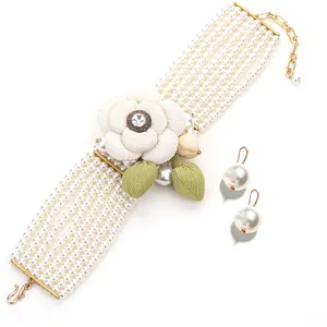 Elegant multi-layer pearl necklace and earring set with camellia flower and green leaves