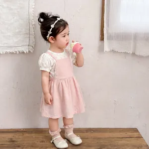 Floral toddler girl outfit with pink suspender dress, white long sleeve top and headband