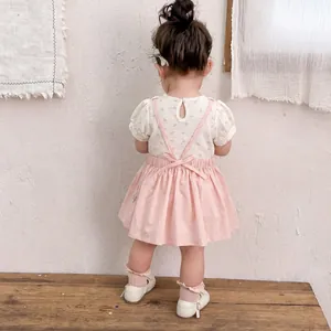 Infant girl floral romper and pink suspender dress two-piece set back view outfit