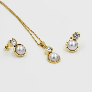 Détail du coffret bijoux avec collier en acier doré et boucles d'oreilles perles