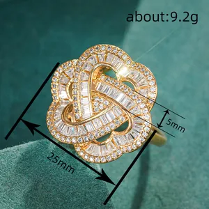 Golden flower knot ring with sparkling zircons on green velvet, 25mm wide, 9.2g weight