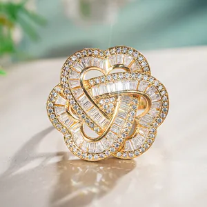 Close-up of golden flower ring with heart-shaped petals and sparkling cubic zirconia