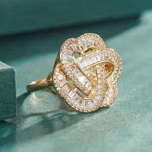 Close-up of golden floral ring with baguette and round cubic zirconia inlays