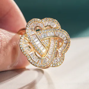 Macro shot of gold floral ring featuring intricate baguette and round diamond settings