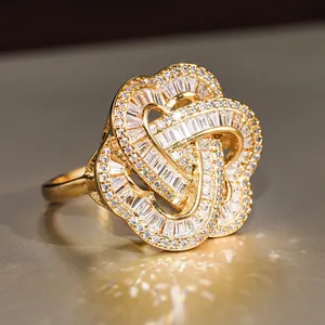 Macro detail of gold-plated woven ring featuring baguette and round zircon pave settings