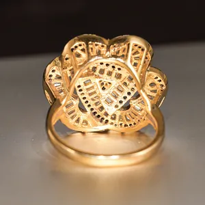 Macro detail of the golden floral ring base showing intricate pave stone settings