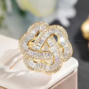 Macro detail of gold intertwined ring with pave set baguette and round zircons